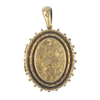 A late Victorian locket. Of oval outline, the ivy leaf engraving to the front to the stepped edges a