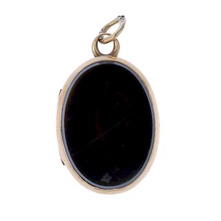 A late Victorian hard stone locket, circa 1870, of oval-shape outline, the onyx and carnelian panels