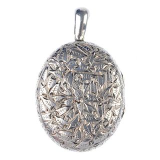 A late 19th century silver foliate engraved locket. Of oval-shape outline with foliate engraved deta