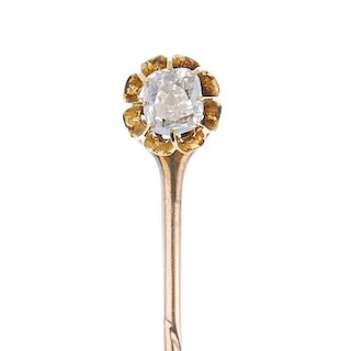 An early 20th century gold diamond stickpin. The old-cut diamond, within an elongated claw surround