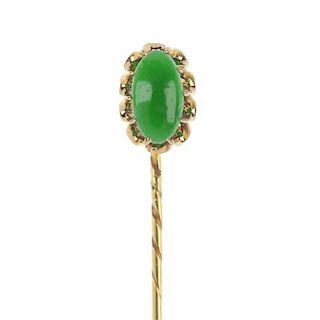 A jadeite stickpin. The oval-shape cabochon jadeite, claw-set vertically to the pin. Length 6.2cms.