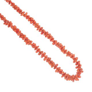 A coral necklace. The single row of fancy-shape coral to the push-piece clasp. Coral untested. Lengt