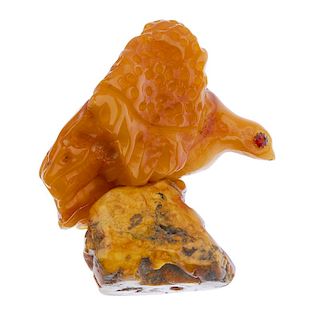 A natural amber ornament. Carved into the form of an eagle, with gem-set eyes, to the freeform natur