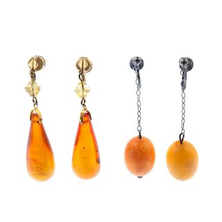 Two pairs of amber earrings. The first designed as oval natural amber beads suspended from fine belc