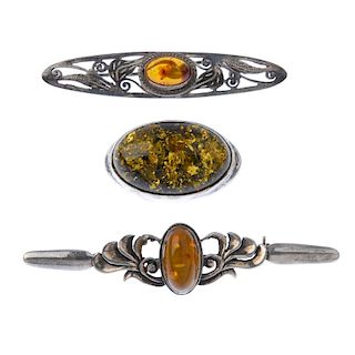A selection of mainly modified amber jewellery. To include a bar brooch with open scrollwork to the
