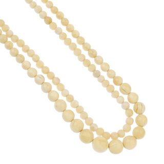 Two early 20th century ivory necklaces. The first designed as sixty-two graduated spherical ivory be
