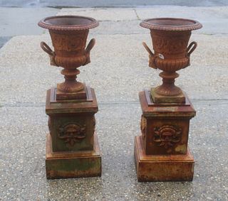 A Pair Of Cast Iron Urns On Stands.
