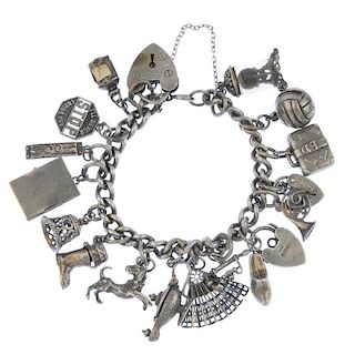 A charm bracelet. Designed as a series of sixteen assorted charms, to include a passport and a mantl