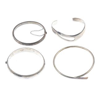 A selection of silver and white metal bangles. Many of hinged or torque design, to include floral en