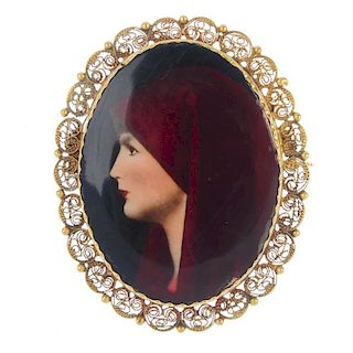 An enamel brooch. The enamel picture of a lady with a red head covering, to the cannettille and bead