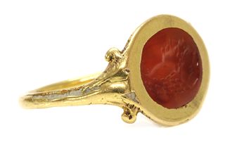 A gold cornelian intaglio ouroboros ring,