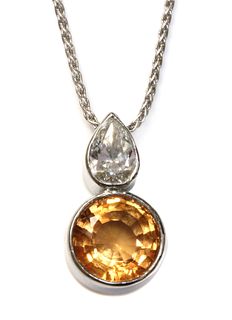 An 18ct white gold topaz and diamond pendant,