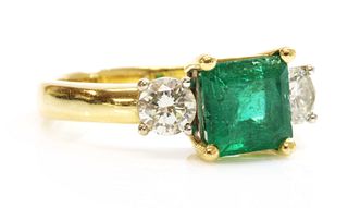 An 18ct two colour gold three stone emerald and diamond ring,
