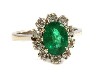 An 18ct white gold emerald and diamond oval cluster ring,