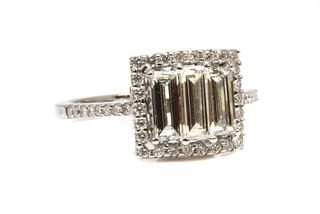 A white gold three stone diamond halo cluster ring,
