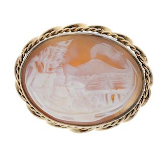 A cameo brooch and a paste bead necklace. The shell cameo brooch, carved to depict a volcanic scene,