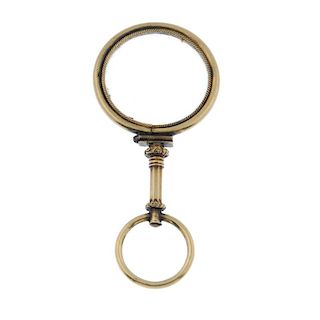 An early 20th century gold magnifying glass. The circular-shape glass panel within a rope-twist bord