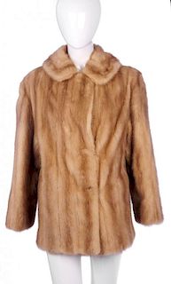 A three-quarter length pastel mink coat. Designed with a notched lapel collar, hook and eye fastenin