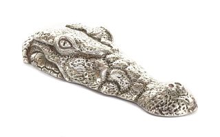 A silver sculpture of a crocodile head, by Patrick Mavros,