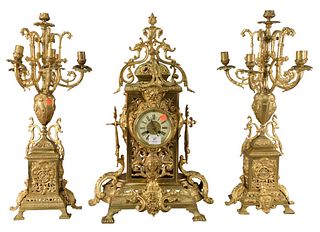 Three Piece Brass Mantle Set, to include a clock and two candelabras, each having mounted faces to the base, height 26 inches.