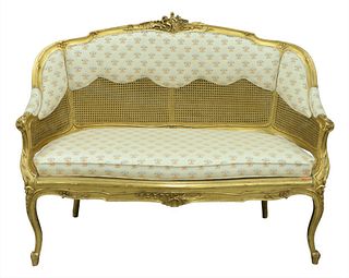 Louis XV Style Giltwood Settee, having caned back and seat with foliate carvings all raised on cabriole legs, height 54 inches.