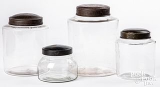 Four tin and colorless glass store counter jars
