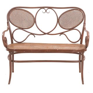 Love seat SXX. Estilo Austriaco. Elaborado en madera Respaldo semiabierto, asiento de bejuco tejido, chambrana oval y soportes lisos.