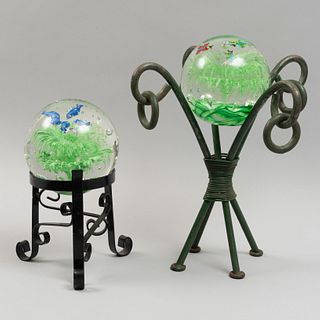 2 esferas decorativas. SXX. Elaboradas en cristal de murano. Acabado somerso. Con pedestal de hierro. Decoradas con motivos orgánicos.