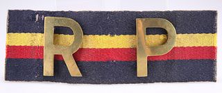 A REGIMENTAL POLICE ARMBAND, of heavy brass letters mounted