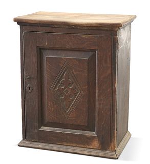 AN 18TH CENTURY OAK SPICE CUPBOARD, with lozenge-carved pan