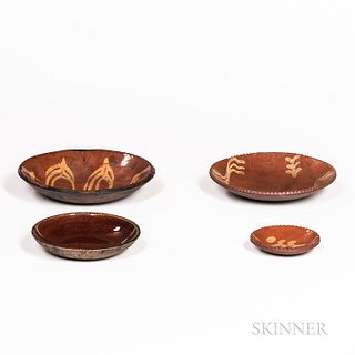 Four Small Redware Plates, 19th century, three with yellow slip design, including a miniature plate, and one with dark mottled glaze, (
