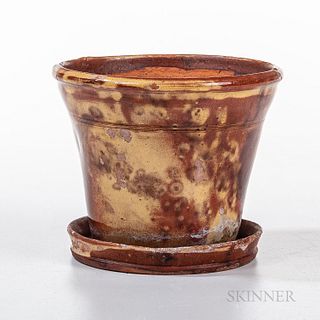 Slip-decorated Redware Flowerpot, Pennsylvania, c. 1850, the pot with line decoration on the neck, integral dish base, mottled red glaz