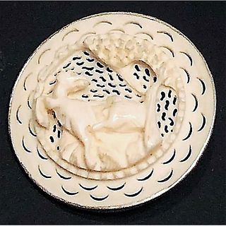 A DIVISION THREE CARVED NATURAL MATERIAL ANIMAL BUTTON