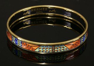 An HermÃ¨s narrow orange enamel gold-plated bangle