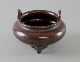 Chinese porcelain twin-handled censer on three feet in a purple lustre glaze, 11.5cm diameter,