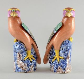 Pair of early 20th century porcelain parrots in coloured glazes on rockwork bases, 27.5cm high,
