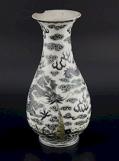 Chinese black and white porcelain vase decorated with a dragon amongst clouds above the ocean, on ro