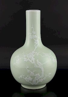 Chinese porcelain bottle vase, the pale celadon ground enamelled in white with two birds in a prunus