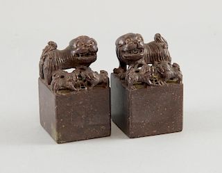 Pair of Chinese brown soapstone carvings of dogs of fo and puppies on integral square bases, 8.5cm h