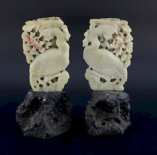 Pair of Chinese soapstone candle holders in the form of phoenix amongst foliage on naturalistic base