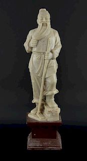 Chinese soapstone carving of a bearded man holding a hoe, on integral plinth base, 40.5cm high,