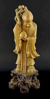 Chinese soapstone carving of Shou Lao, holding his staff and a peach, on naturalistic base, 39.5cm h