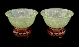 Pair of Chinese mottled green hardstone bowls on pierced wood stands, 10cm diameter,