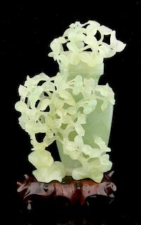 Chinese green jadeite vase and cover with carved and pierced foliate decoration, on hardwood stand,