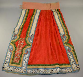 19th C Chinese male skirt, of brocaded red silk, pleated on the reverse, front appliqu‚d with figure