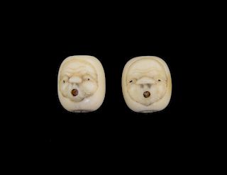 Pair of Japanese bone beads with mask decoration, the mouths of the masks with articulated dice inse