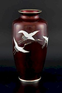 Ando Jubei, silver wired red ground cloisonne vase decorated with a flight of cranes, 21cm high,