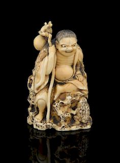 Japanese carved ivory figure sitting on a rock base holding a staff with a double gourd attached and