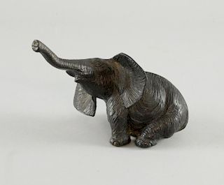 Japanese cast bronze model of a seated elephant with it's trunk raised in the air, 11.5cm high,
