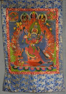 Tibetan Thangka painting depicting a many armed and legged figure with horned animals head being emb